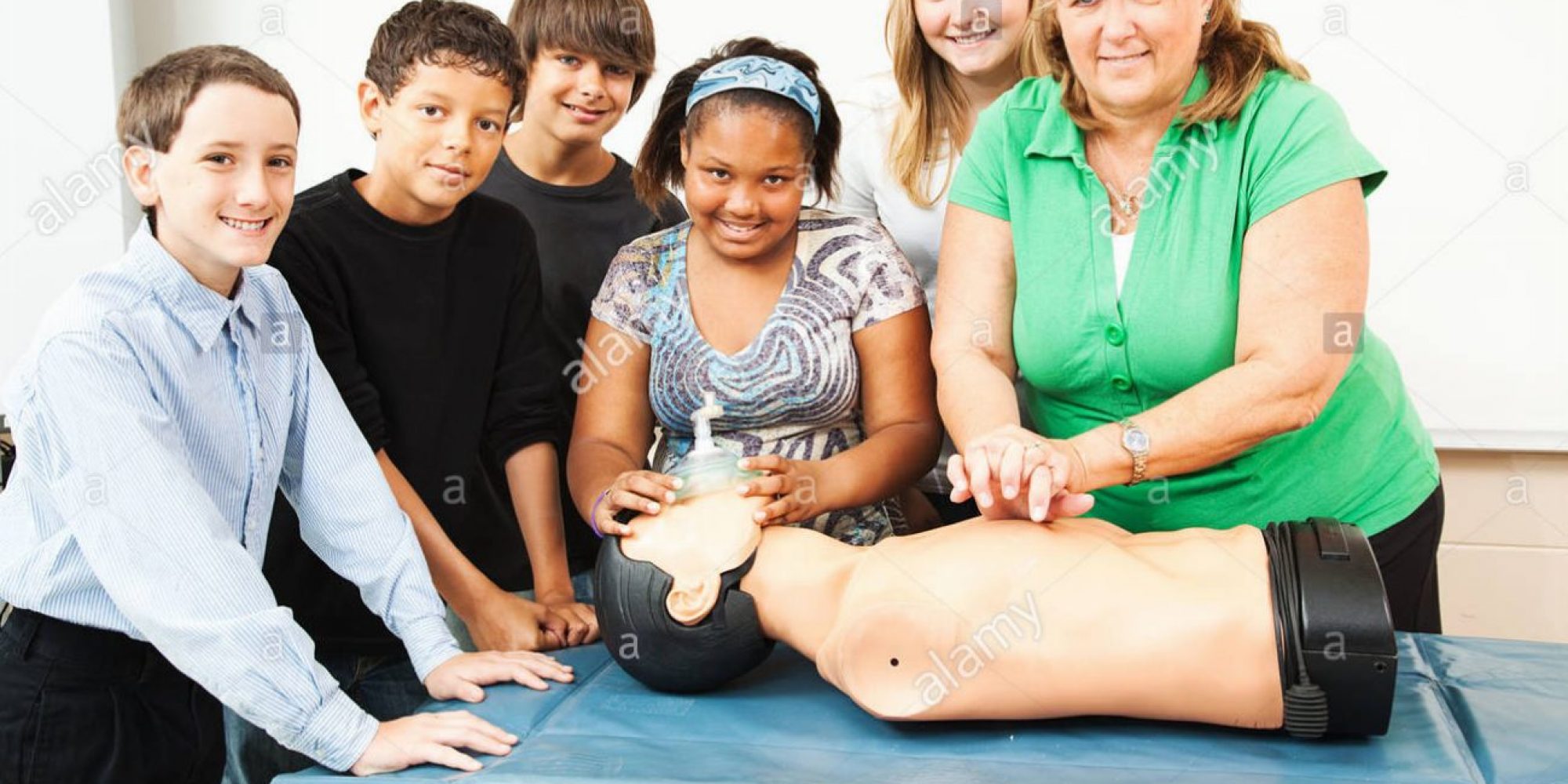 group-of-students-and-their-teacher-learning-cpr-in-school-CP9T4Y